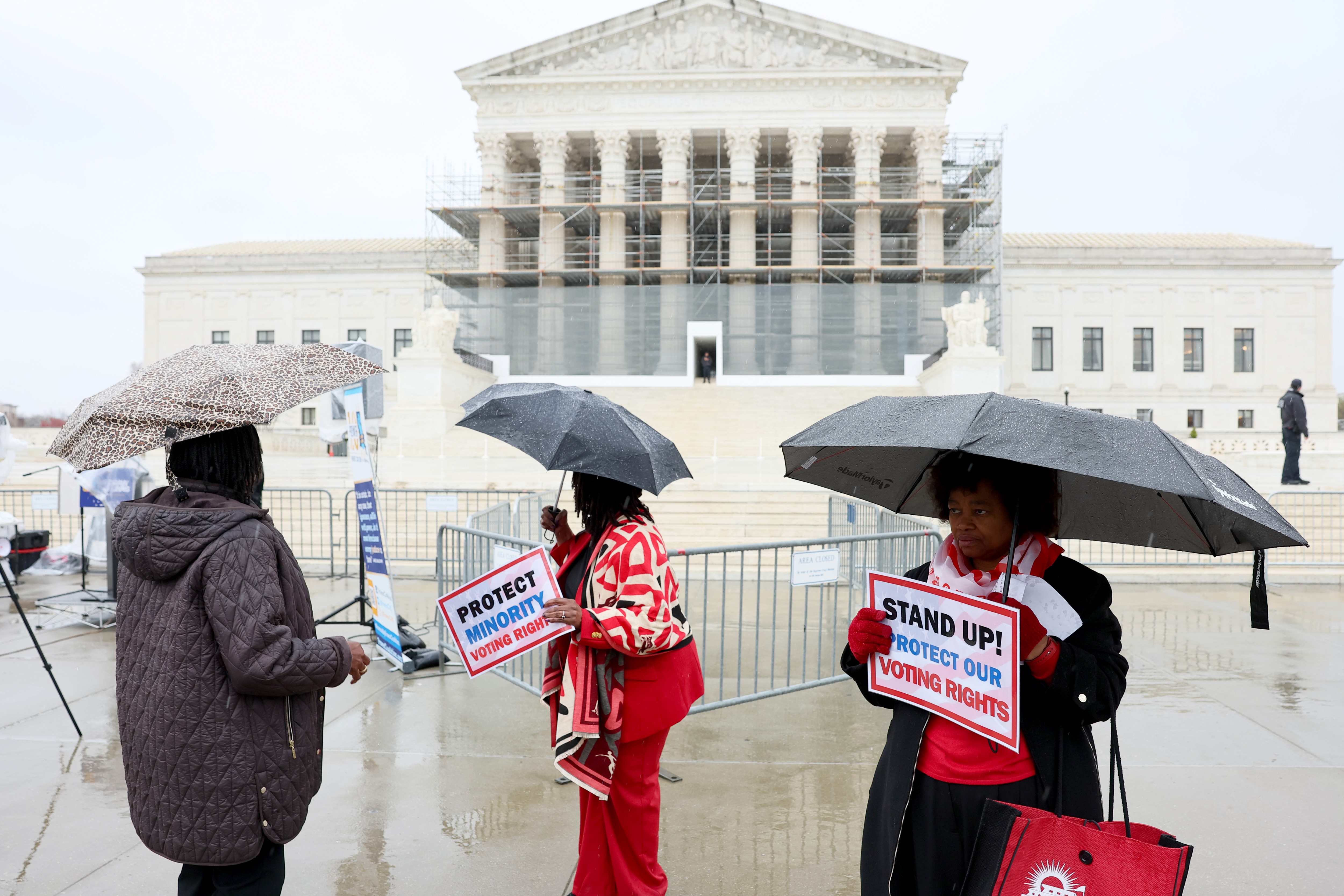 Demonstrators holding signs in support of minority voting rights stand outside the U.S. Supreme Court in Washington, D.C., in March.